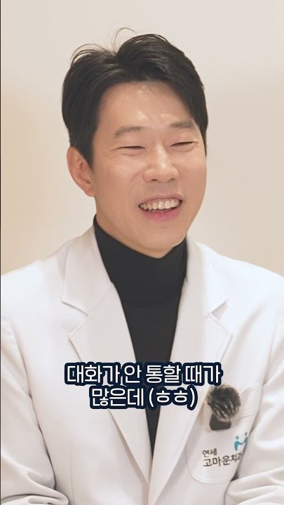 질문에 답하며 웃는 치과의사의 세로형 장면